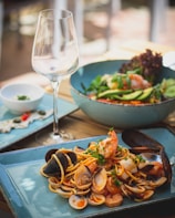 a plate of clams and a glass of wine on a table