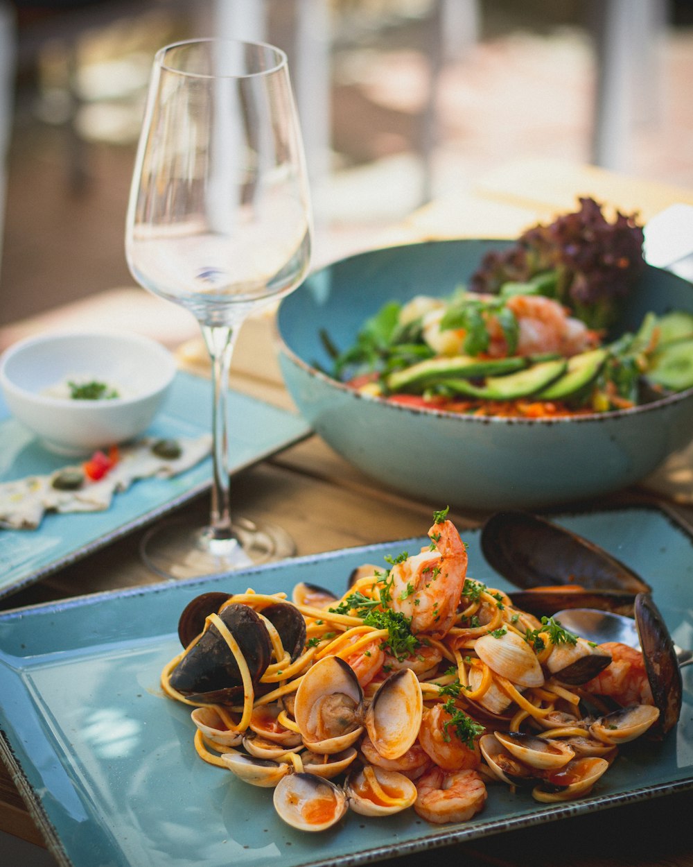 a plate of clams and a glass of wine on a table