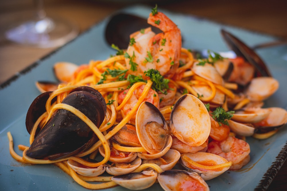 a plate of pasta with clams and shrimp