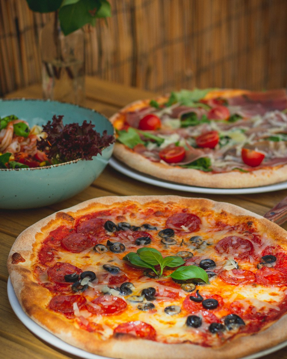 a couple of pizzas sitting on top of a wooden table