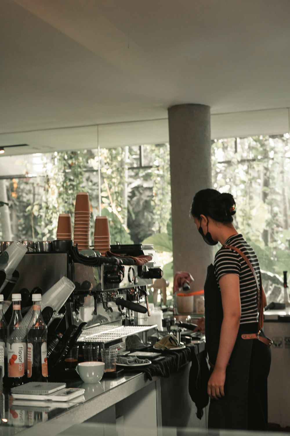 a woman standing in front of a counter filled with bottles