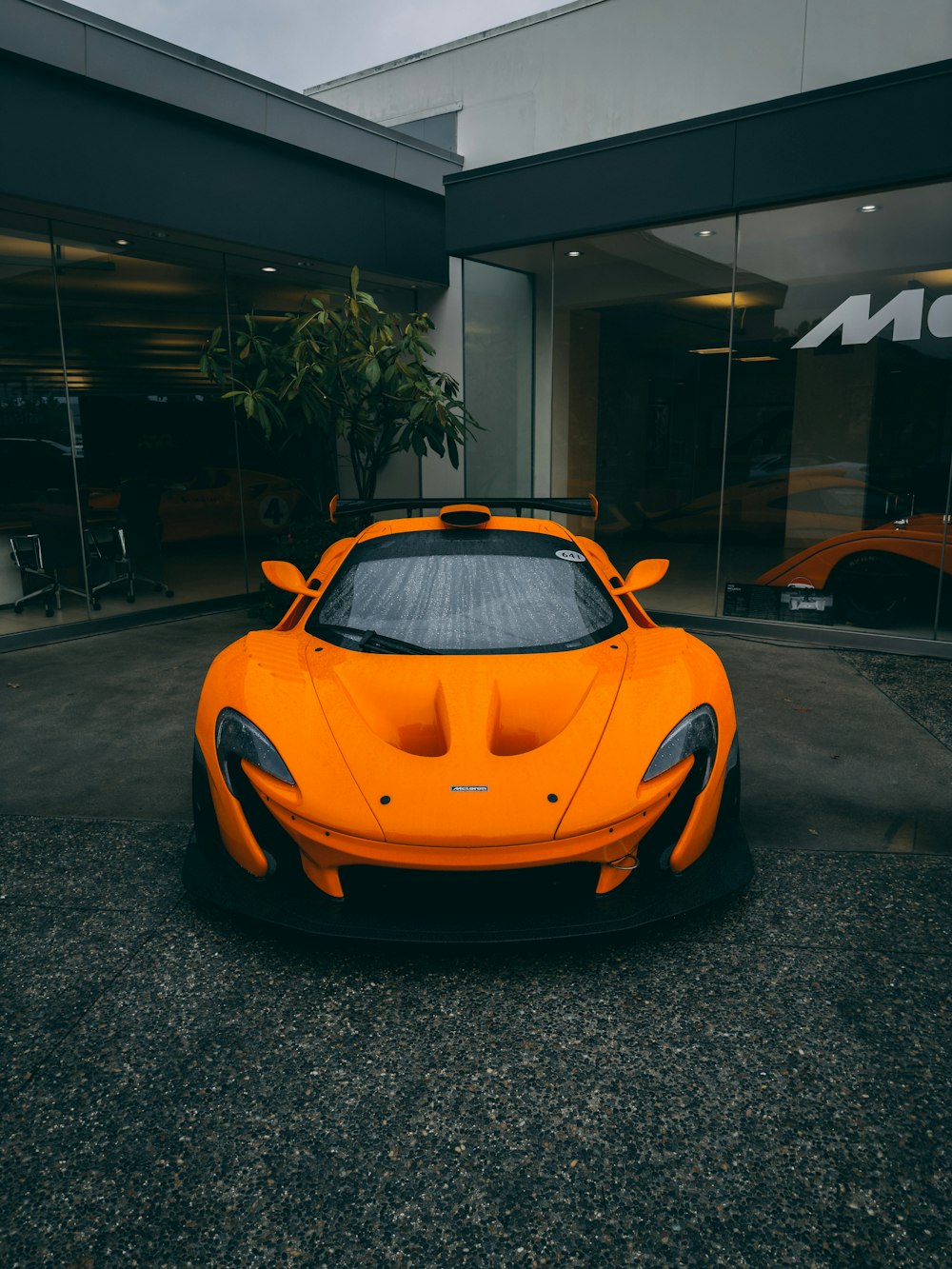 an orange sports car parked in front of a building