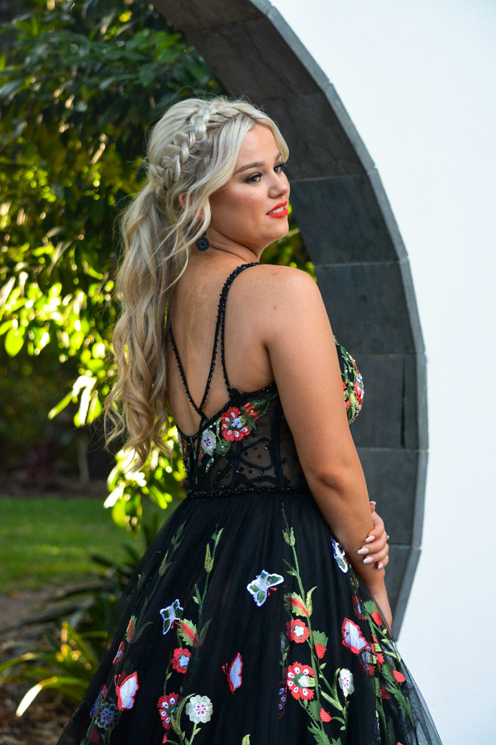 a woman wearing a black dress with flowers on it