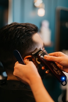a man getting his hair cut by a hair stylist