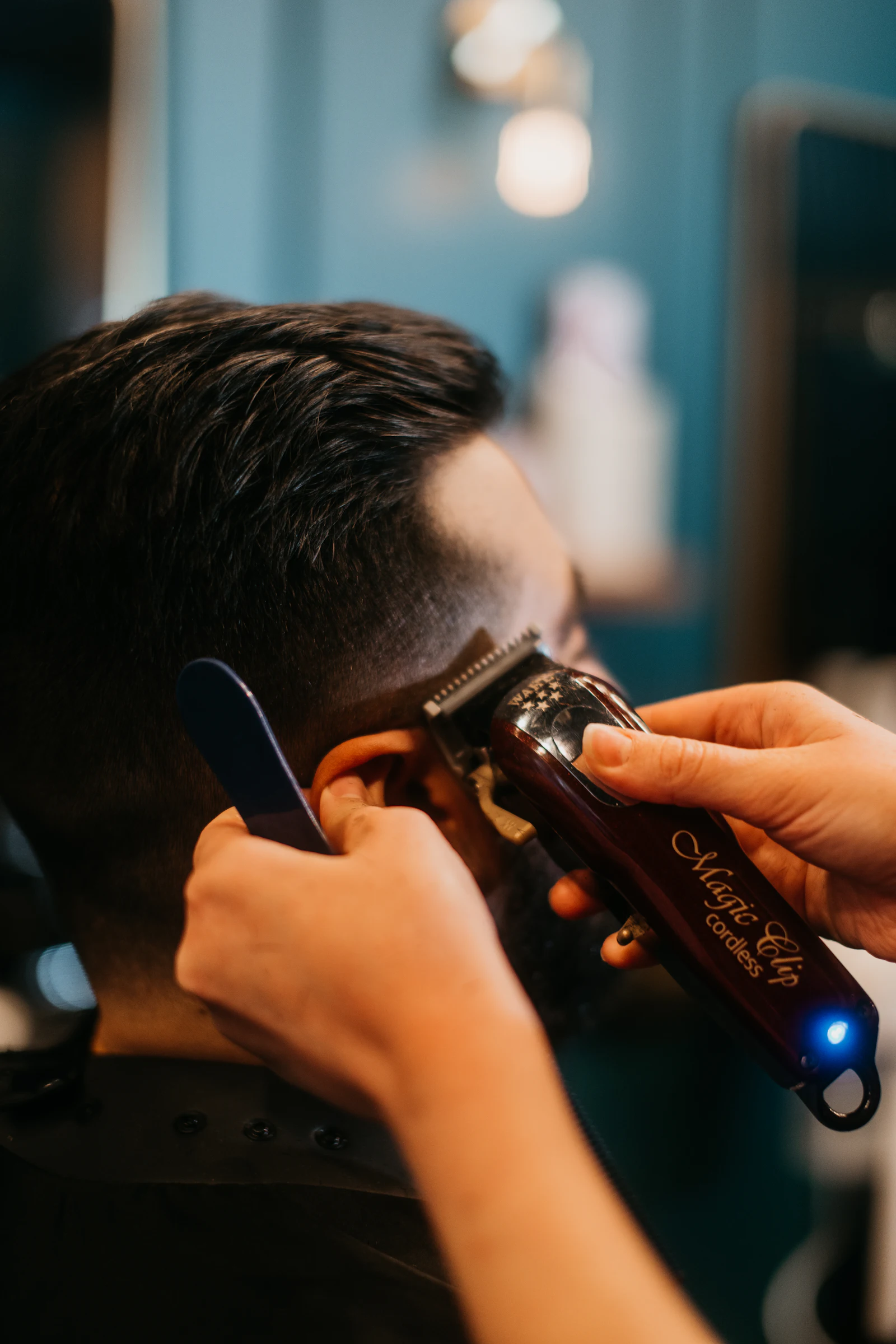 A barber giving a client a haircut at Tanner & Strop