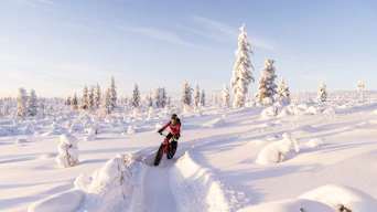 a person riding a snow bike on a snowy surface