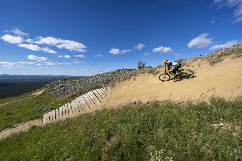 a man riding a bike down a dirt hill