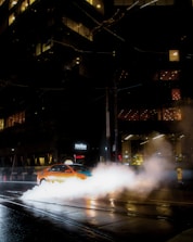 A taxi driving through city streets during the day.
