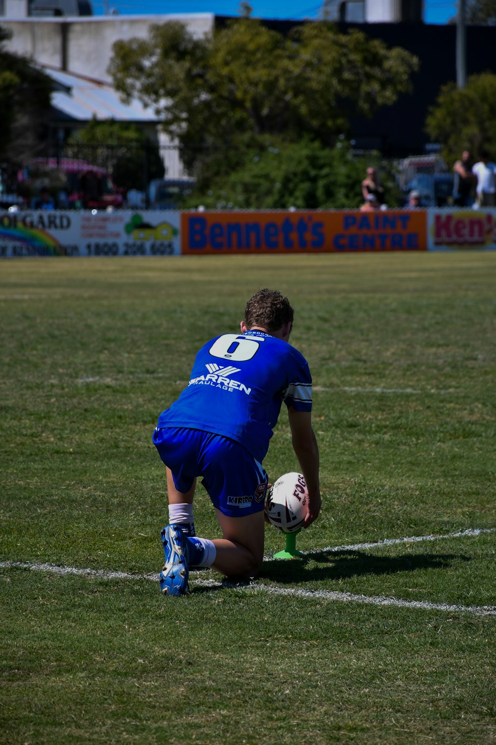 a man kneeling down on a soccer field