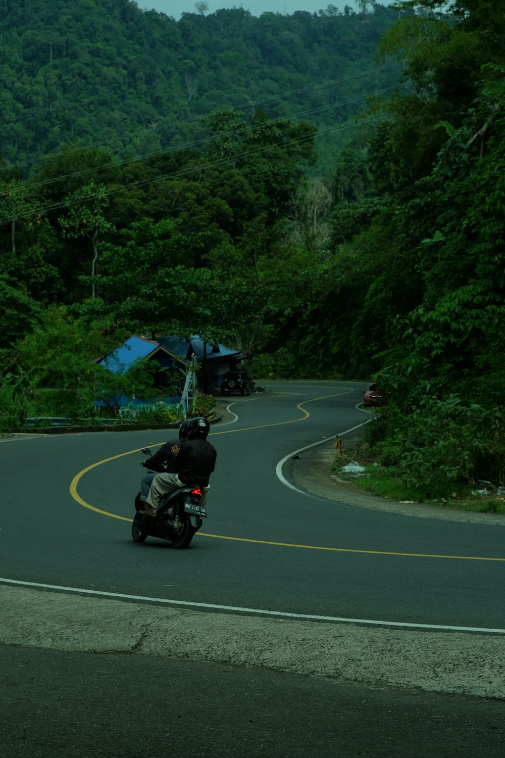 a man riding a motorcycle down a curvy road