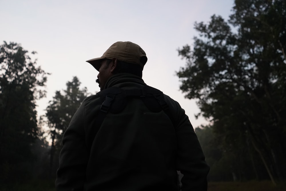 Ein Mann steht auf einem Feld mit Bäumen im Hintergrund