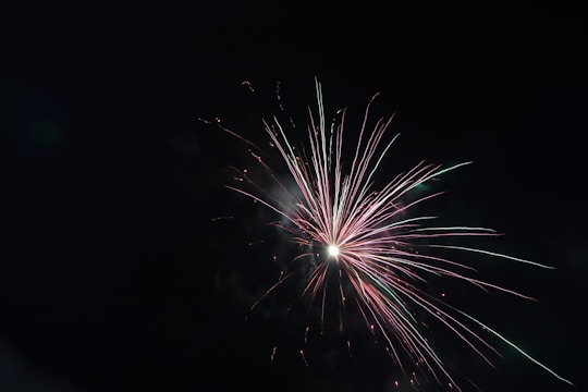 Close-up of colorful fireworks launching into the night sky with vibrant trails.