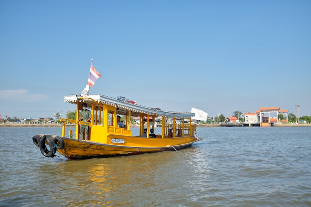 a yellow boat floating on top of a body of water