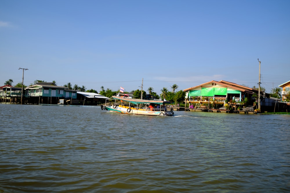 a boat traveling down a river next to houses