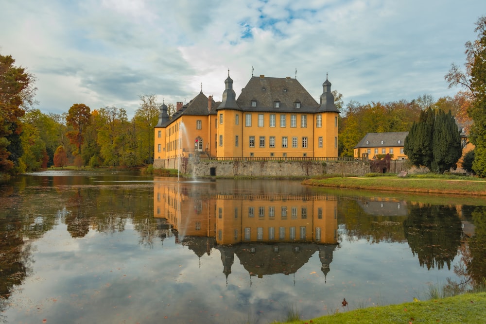 a large yellow building sitting next to a lake