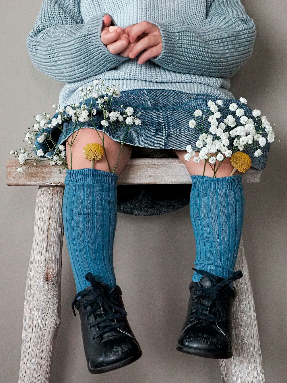 a woman sitting on top of a wooden stool