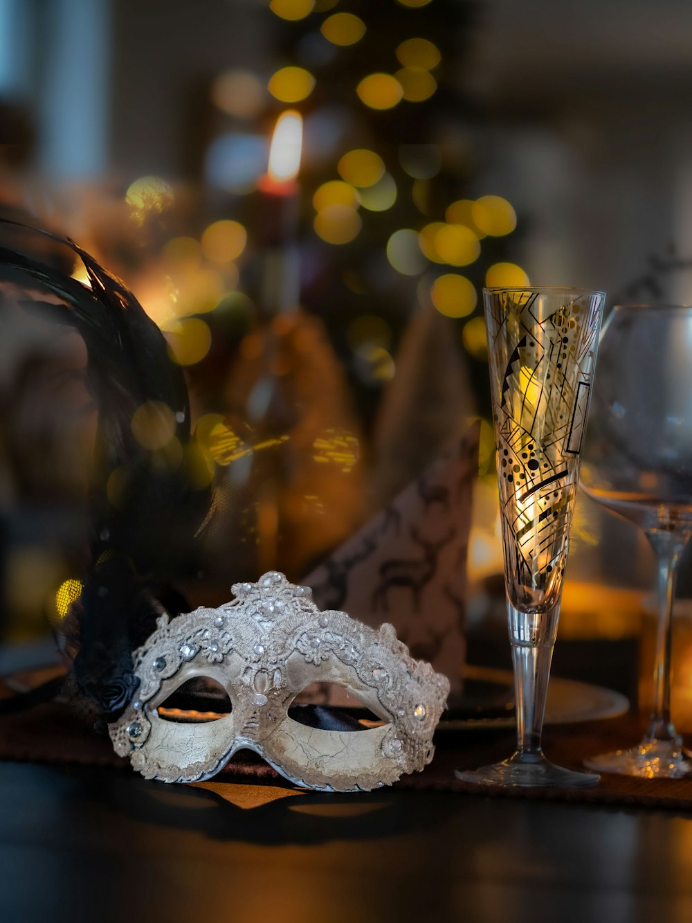 a masquerade mask and a glass of wine on a table