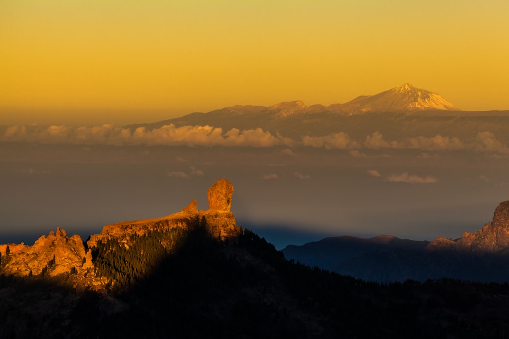 a view of a mountain range with clouds in the foreground