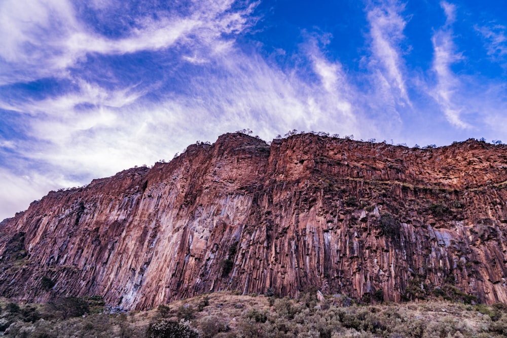 a very tall mountain with some clouds in the sky