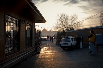 A serene view of pilgrims walking towards the Kaaba under a golden sunset.