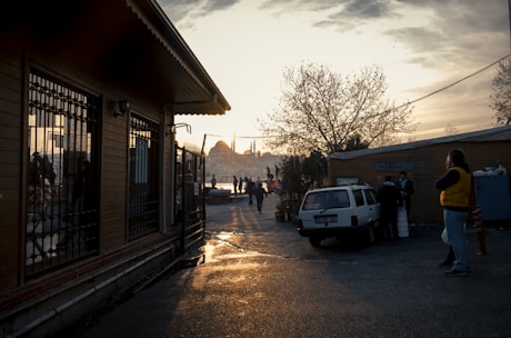 A serene view of pilgrims walking towards the Kaaba under a golden sunset.