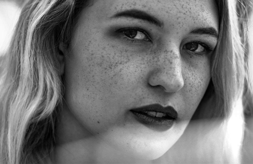 a black and white photo of a woman with freckled hair