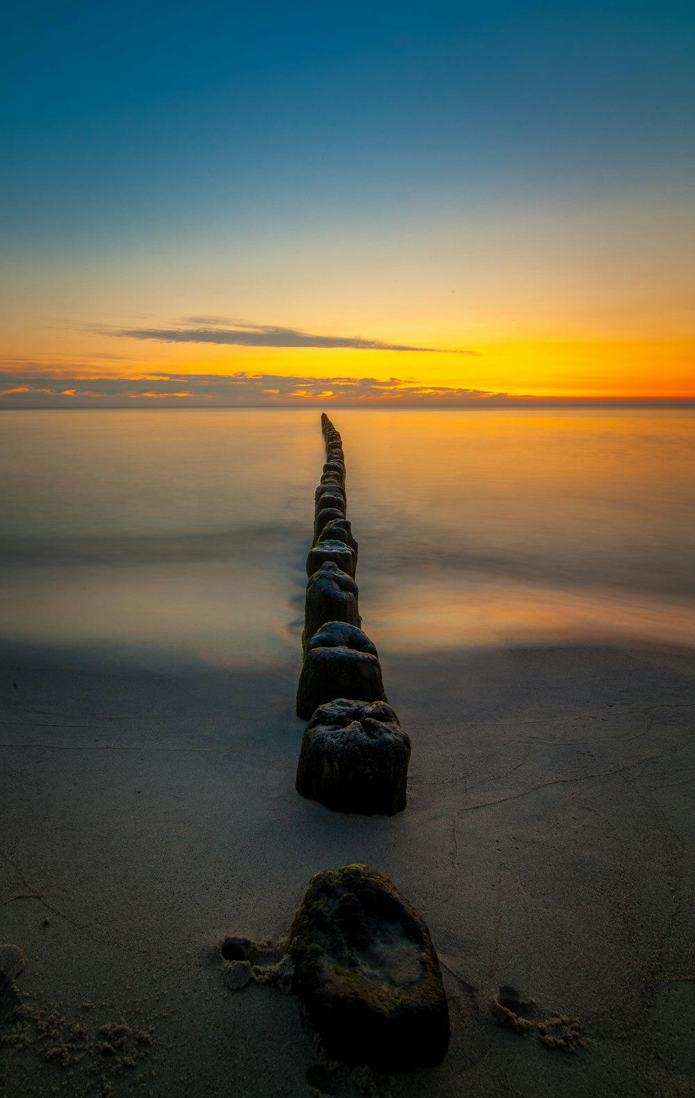 a long line of rocks sitting on top of a beach