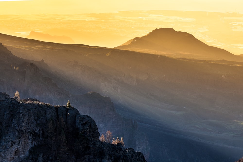 the sun is setting over a mountain range