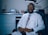 a man in a lab coat and tie sitting in a chair