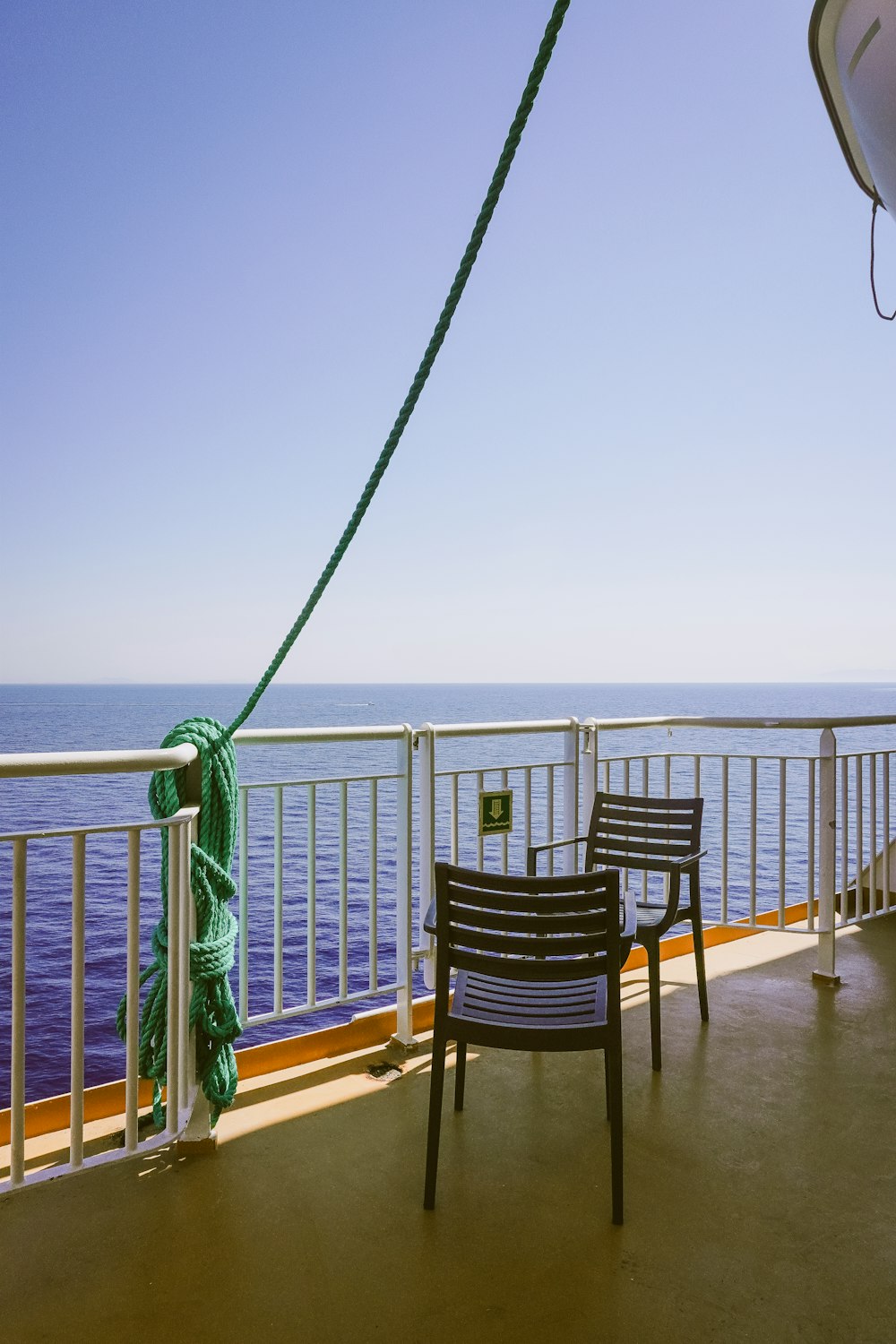 a couple of chairs sitting on top of a balcony