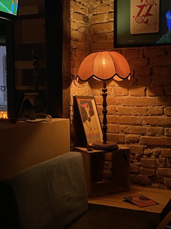 A cozy room softly lit by vintage brass sconces and nautical lamps from Ju Zu International.