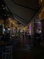 Tourists laughing and chatting under string lights at Jem Bar’s cozy outdoor seating.