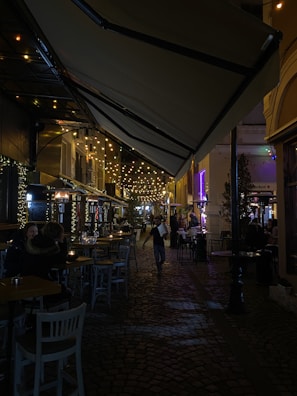 Tourists laughing and chatting under string lights at Jem Bar’s cozy outdoor seating.