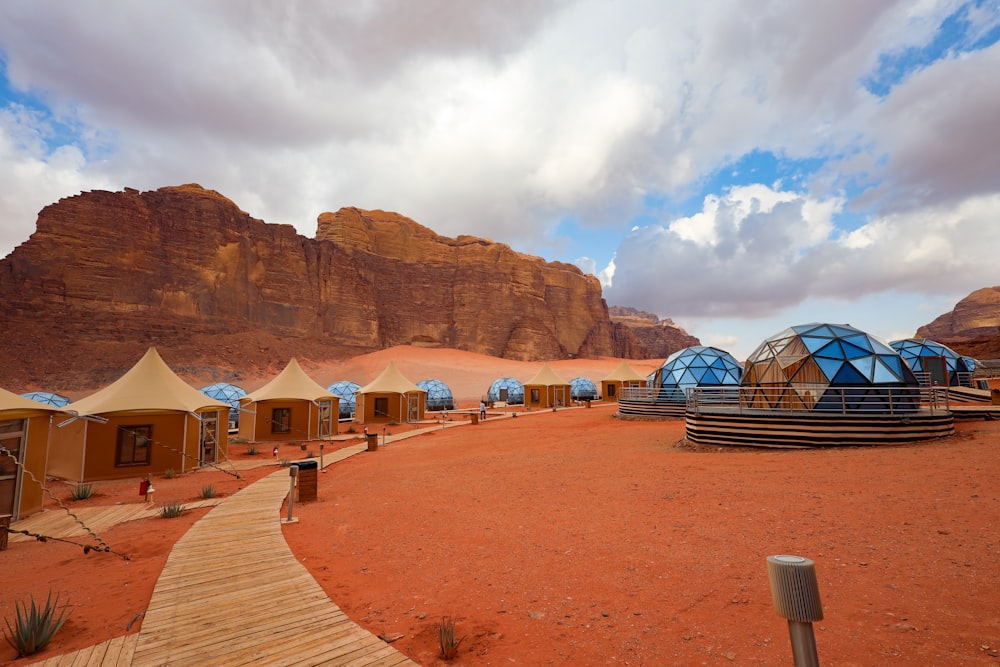 a group of tents in the desert with mountains in the background