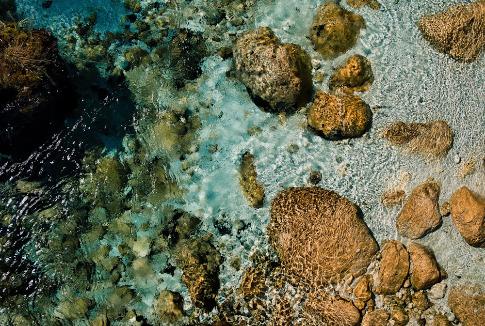 an aerial view of rocks and water in the ocean