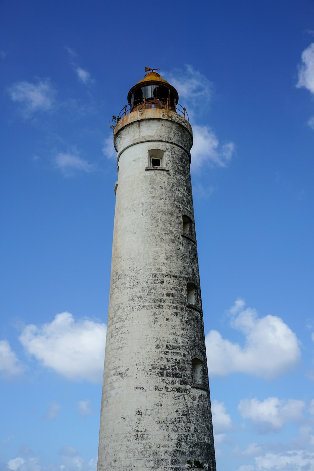 a tall light house sitting on top of a lush green field