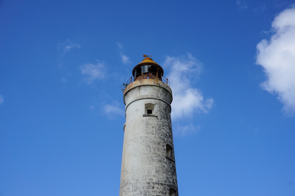 a tall light house sitting under a blue sky