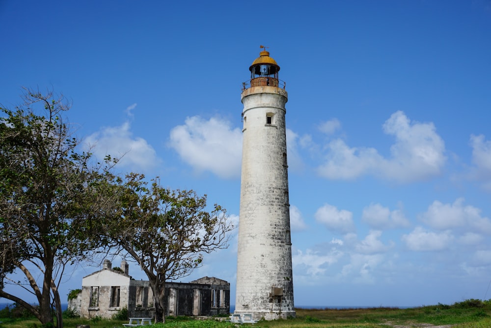 a light house sitting on top of a lush green field