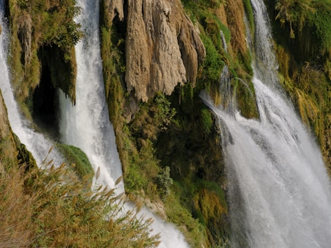 The lush cascading waterfalls of Tumpak Sewu framed by green cliffs.