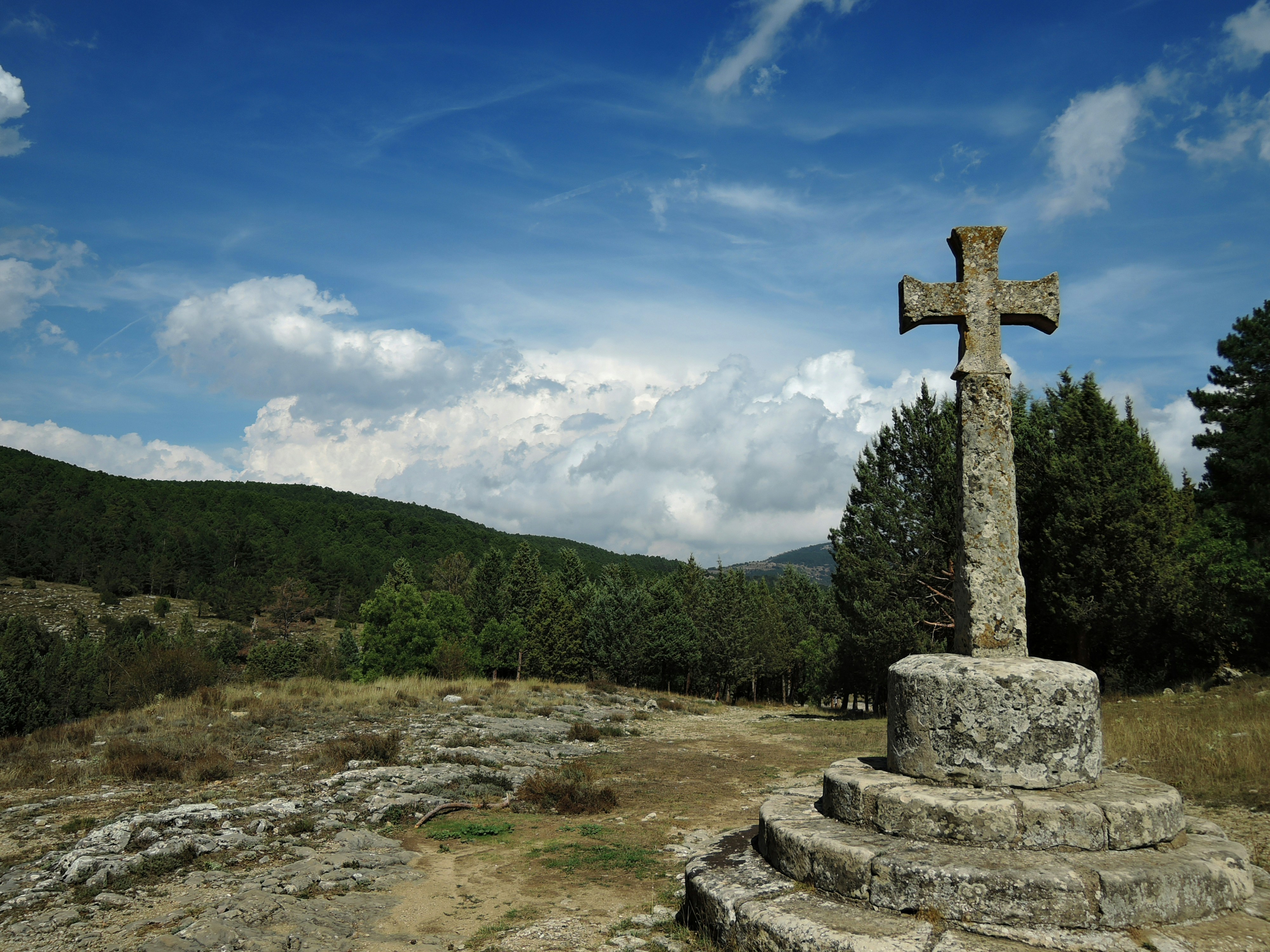 a stone cross sitting on top of a hill