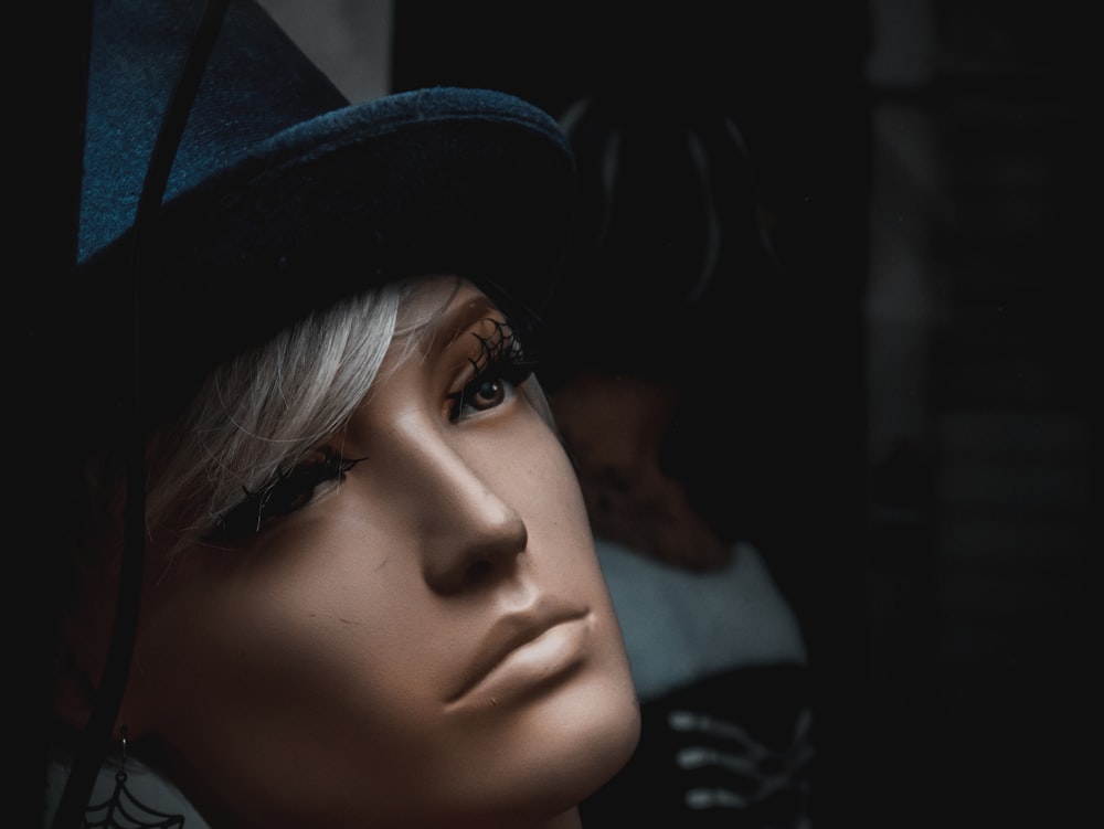 a close up of a mannequin's head wearing a hat