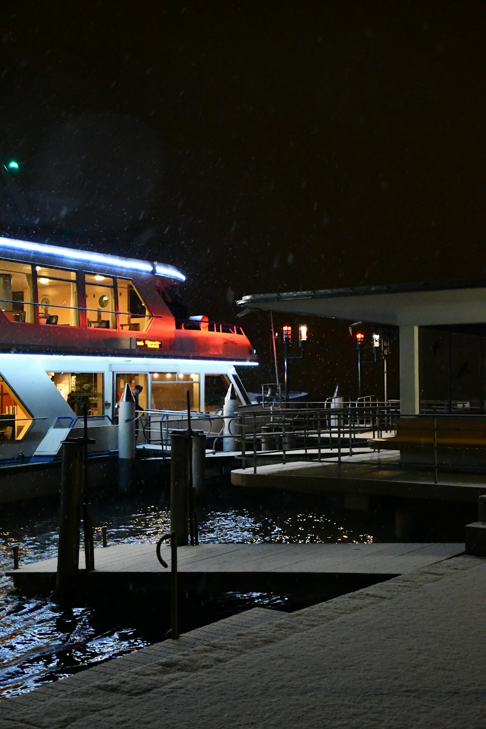 a boat docked at a pier at night