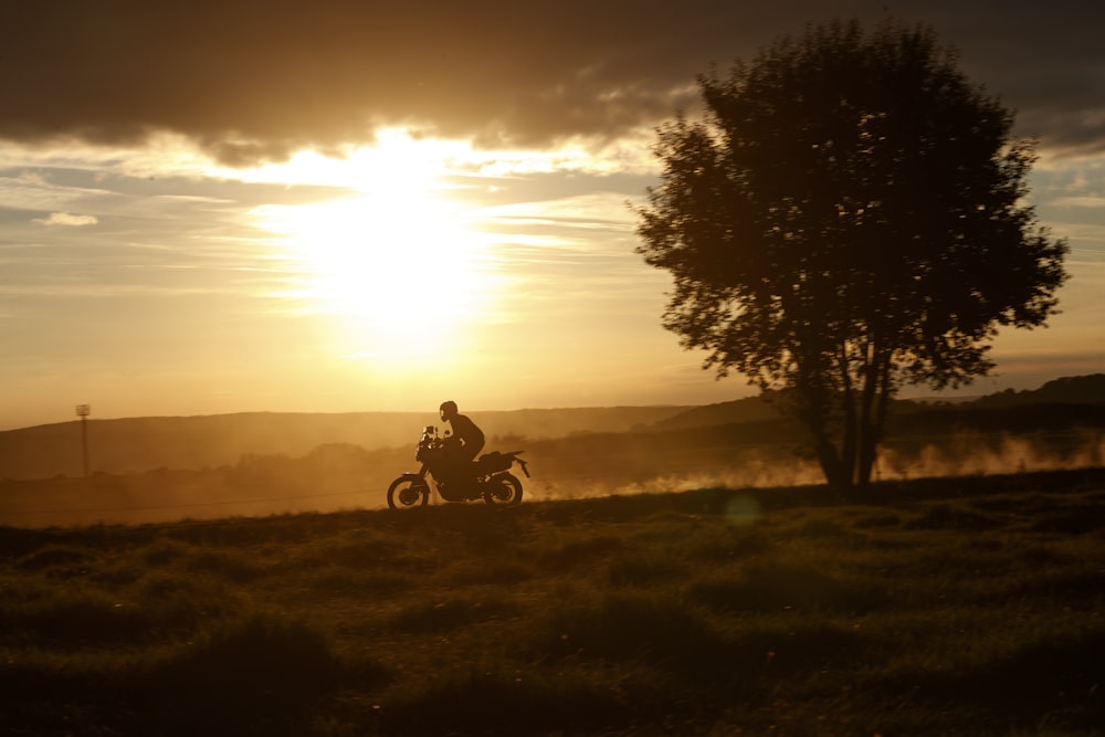 a person riding a motorcycle on a grassy hill