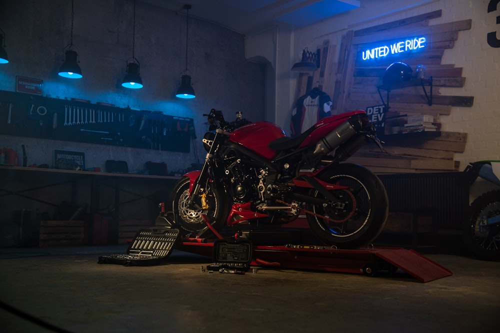 a red motorcycle sitting on top of a lift