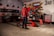 Motorcycle parts and tools neatly arranged on a wooden workbench in a garage.
