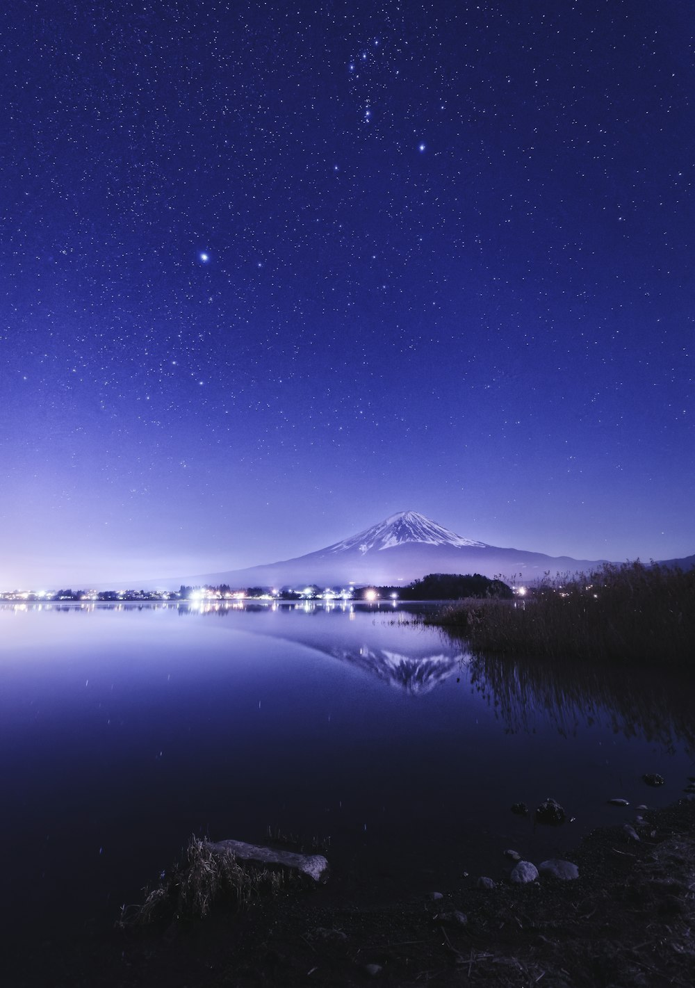 a lake with a mountain in the background at night
