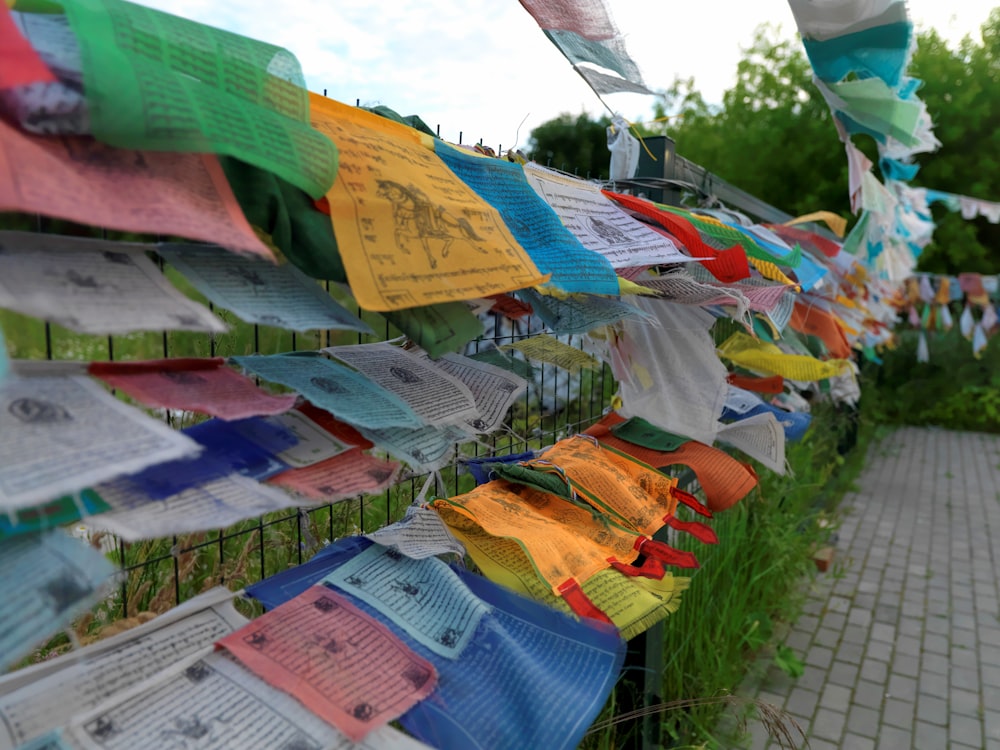 Una hilera de banderas coloridas colgando de una valla