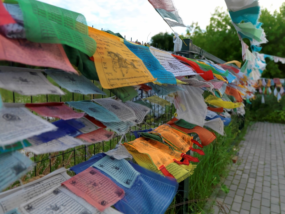 a row of colorful flags hanging from a fence