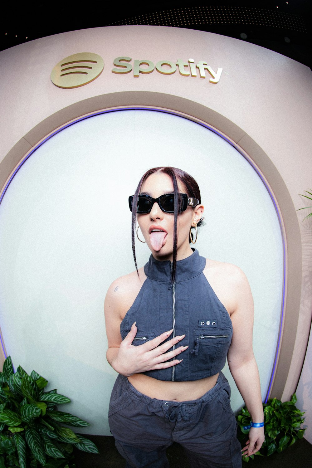 a woman sticking her tongue out in front of a sign