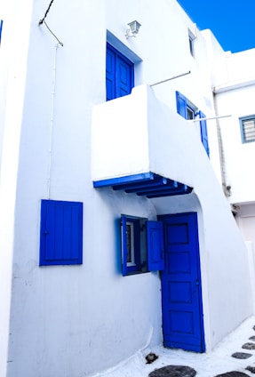 Exterior view of Santorini-style co-living house in Sleman with white and blue accents.